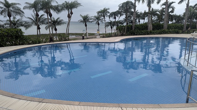 プールと生け垣、その向こうの海